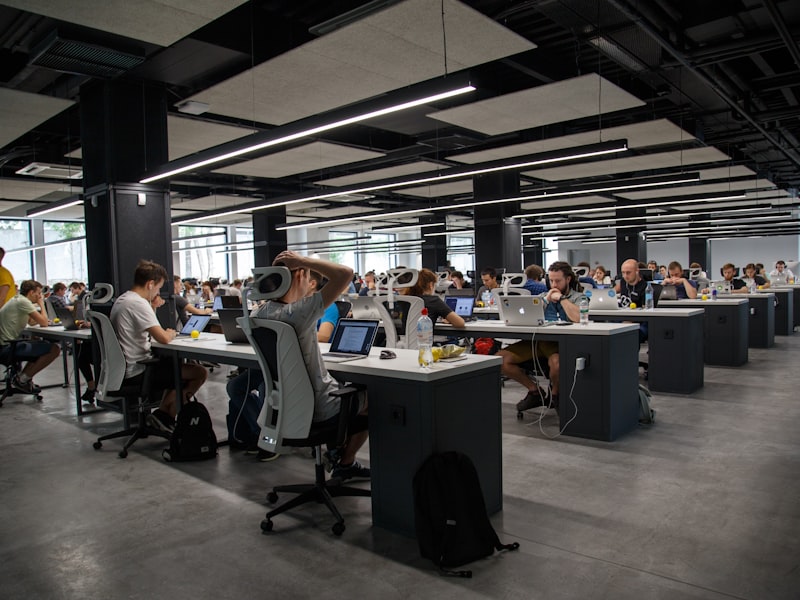 Open-plan office with professionals using smartphones and laptops on Wi-Fi